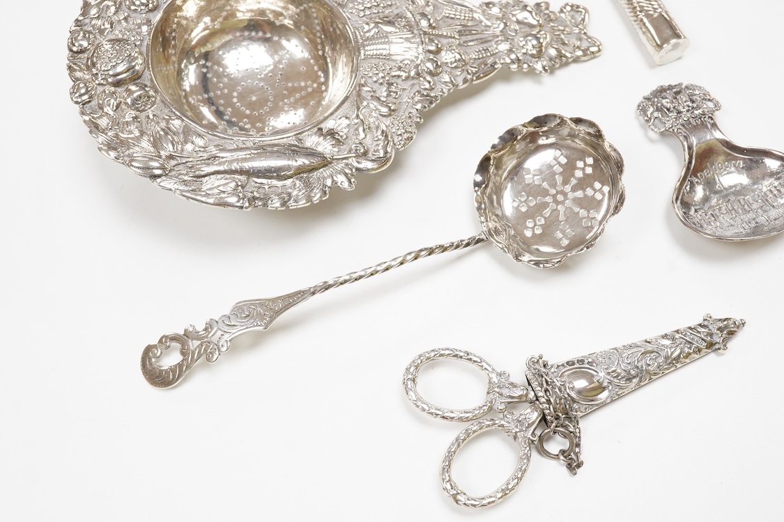 Small silver and white metal, including an Edwardian silver tea strainer, import marks for London, 1908, 15.7cm, a late Victorian silver sifter spoon, silver handled scissors with case, a white metal corkscrew and a whit